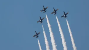 en formation stridsflygplan flyger i himlen och raka strimmor ses bakom dom.