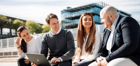 Medarbetare sitter utomhus och diskuterar